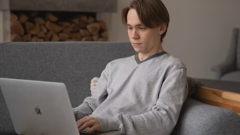 Man using a MacBook on a Couch